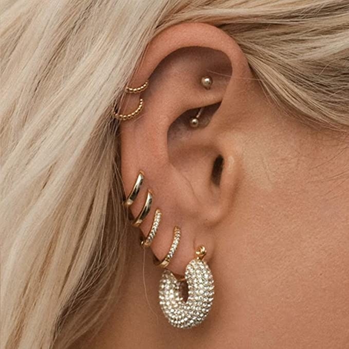 a close up of someone wearing the earrings on their ear stack
