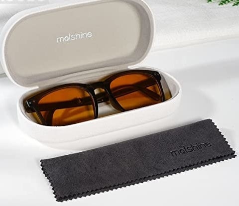 a pair of sunglasses in a case beside a polishing cloth