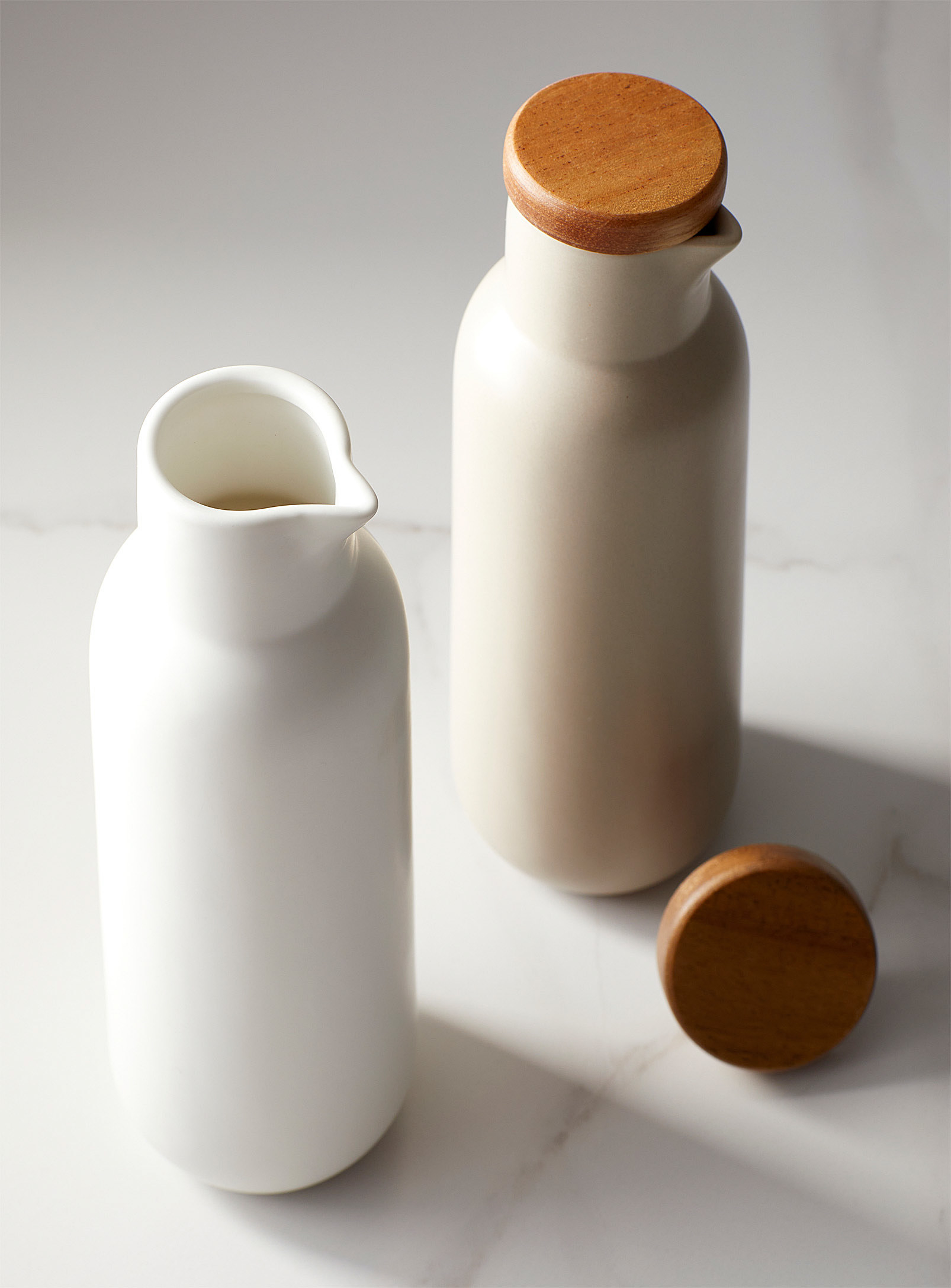 The two bottle on a marble counter, one has its lid off