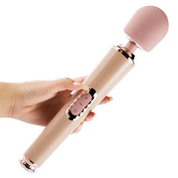 Hand holding light pink and beige wand vibrator