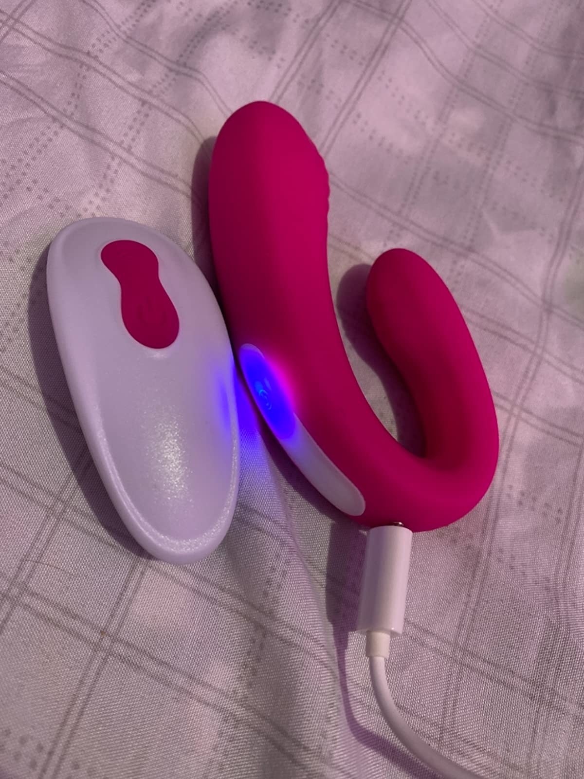 Pink wearable vibrator next to white wireless remote