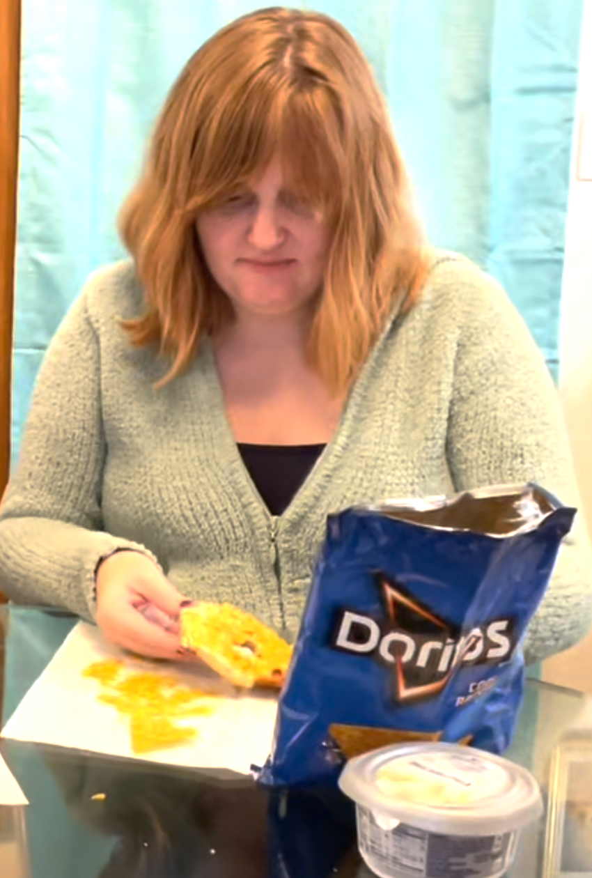 author eating a bagel with doritos on top