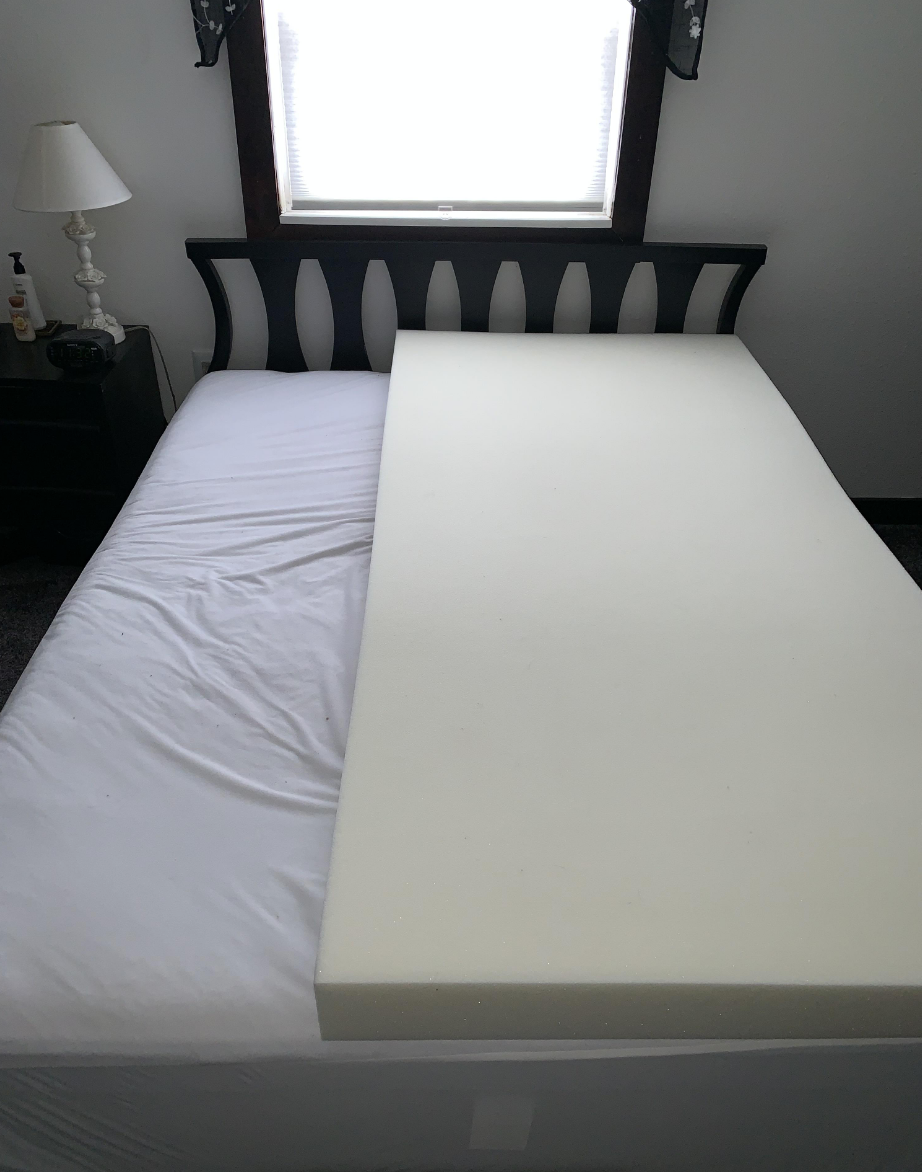 A memory foam mattress on top of a regular mattress