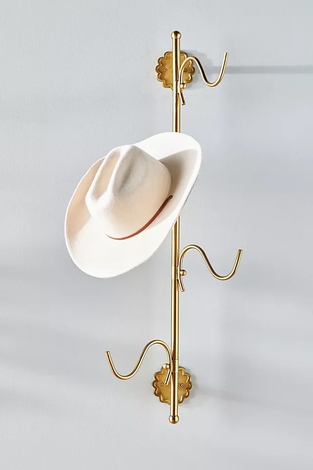 A gold rack in a home with a white hat