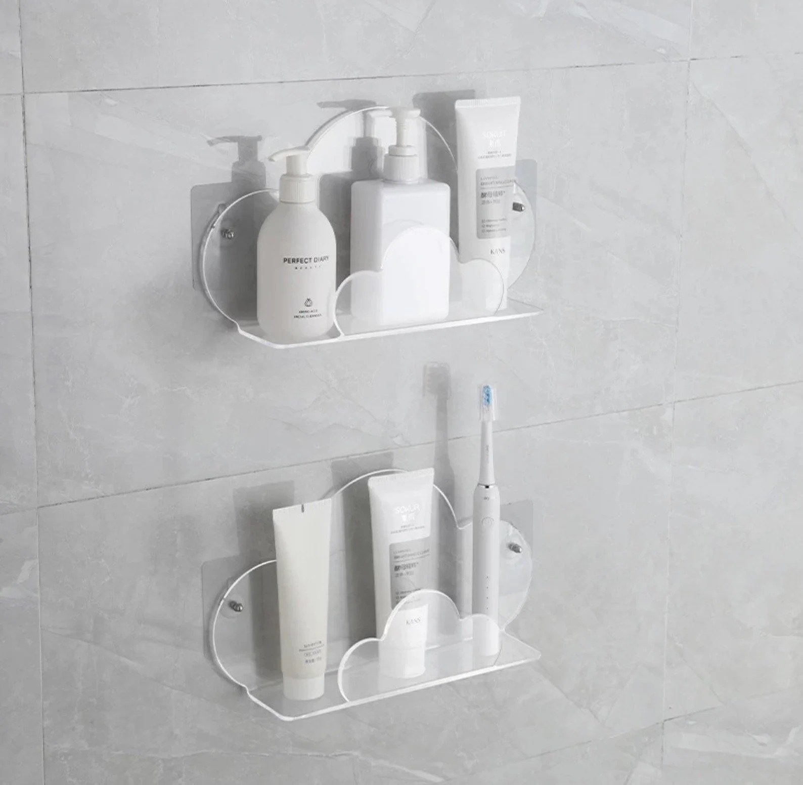 A shower with two white cloud-shaped shelves with white skincare/haircare bottles on them