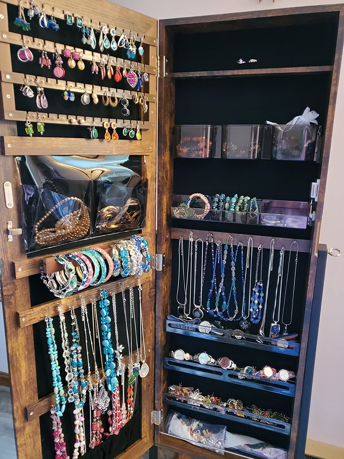 An interior picture of a reviewer's jewelry collection inside a jewelry cabinet