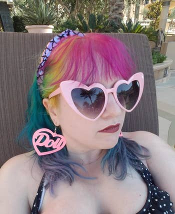 a reviewer wearing pink heart-shaped sunglasses
