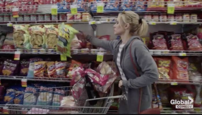 a woman food shopping throwing items off a shelf into her cart