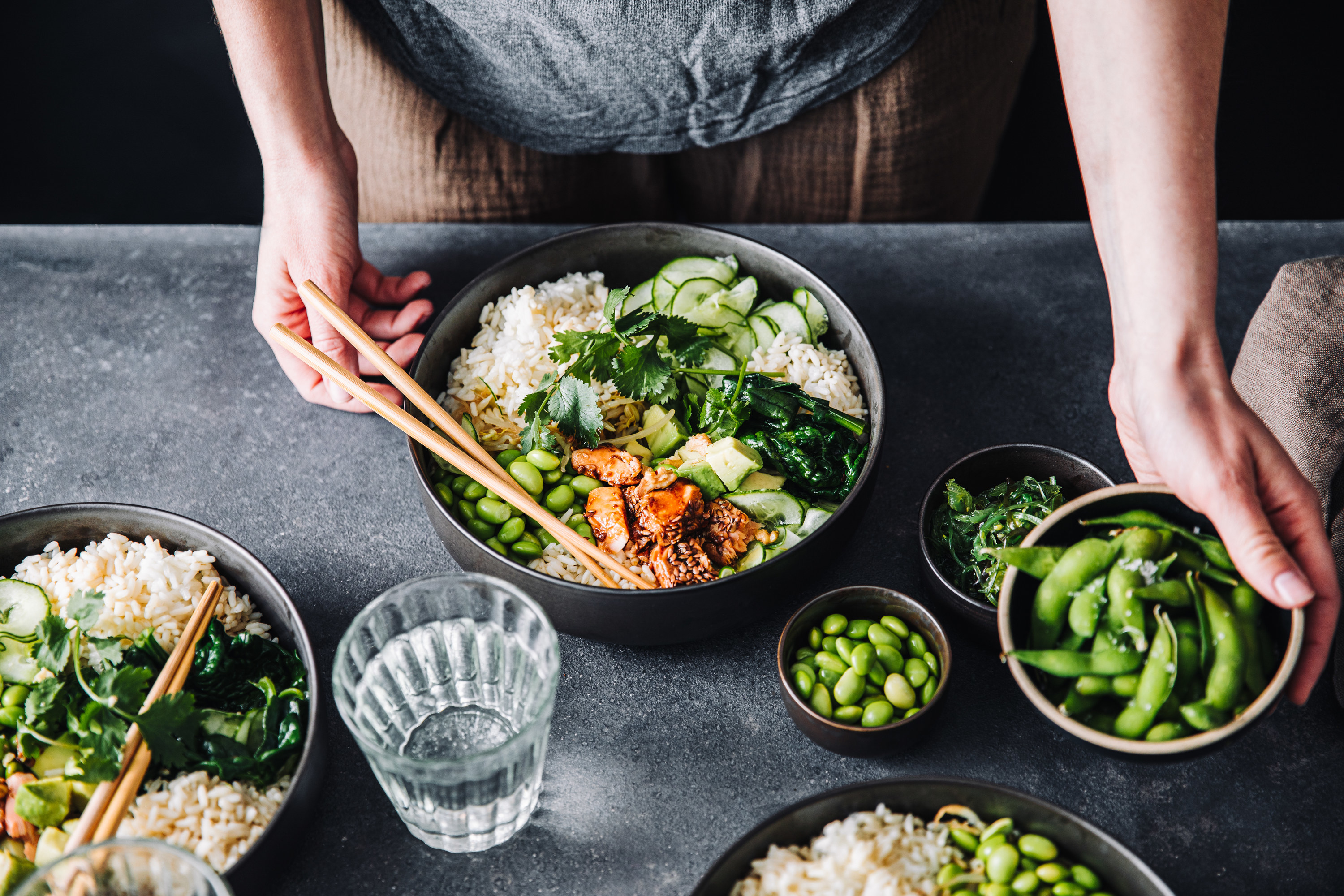 Someone eating a healthy bowl with greens, salmon and rice