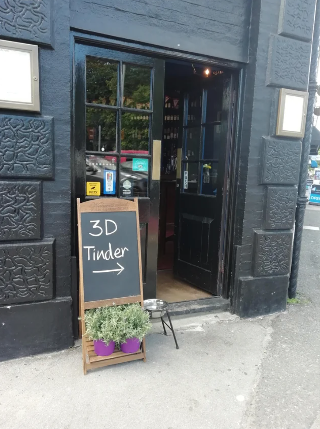 Sign outside a bar that says &quot;3D Tinder&quot; with an arrow