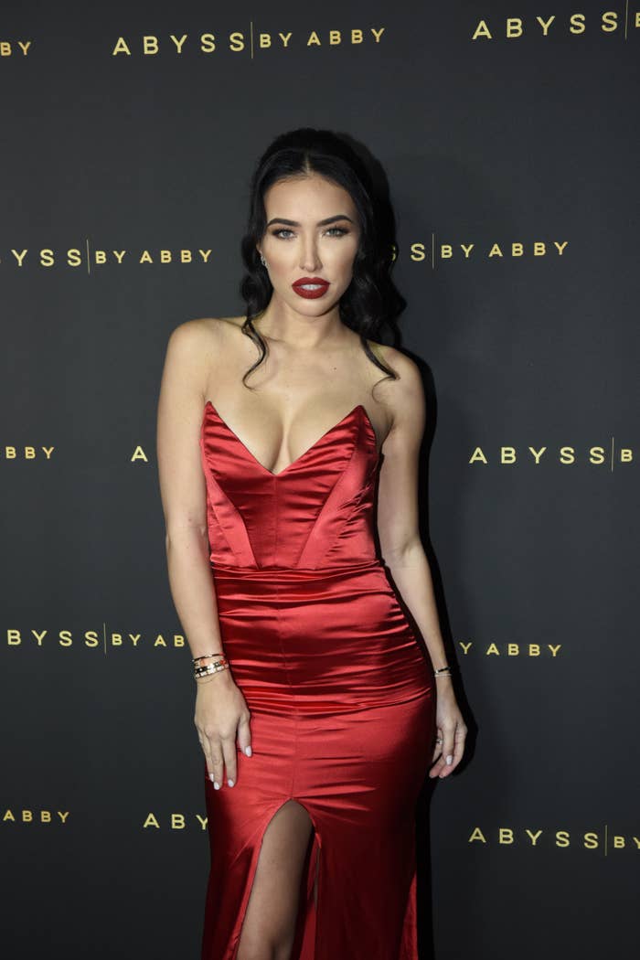 Bre poses on the red carpet while wearing a satin sleeveless dress with a plunging neckline and her hair pulled back