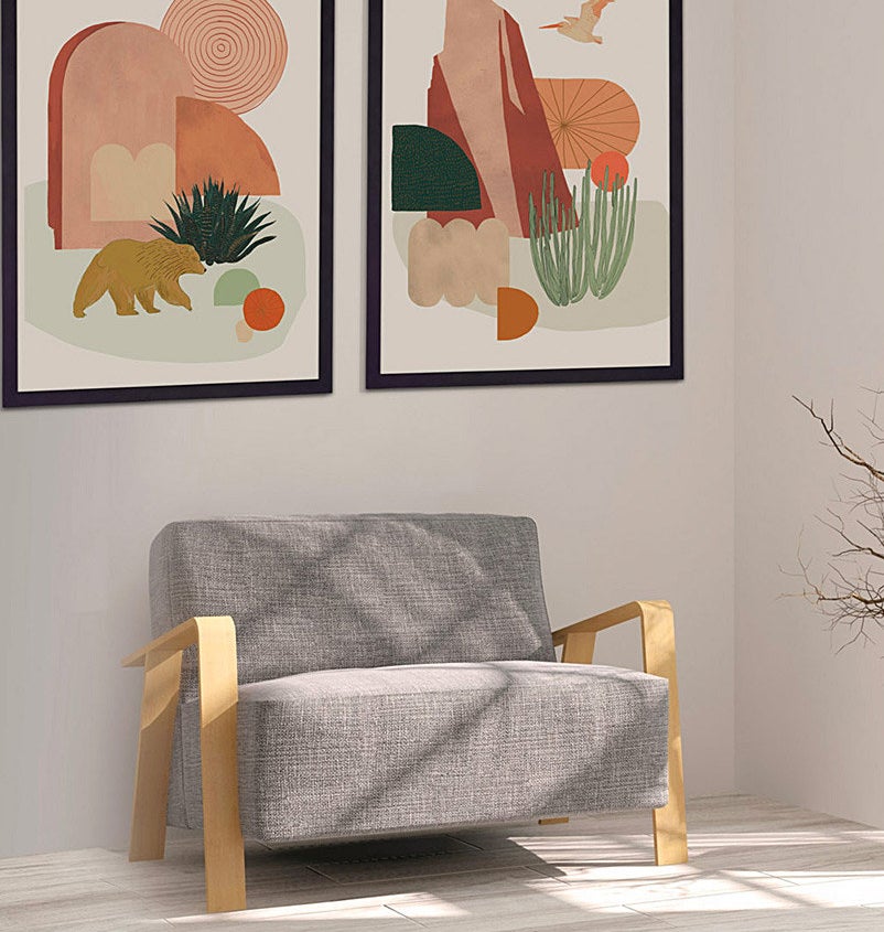 the pair of prints framed and hanging over a chair