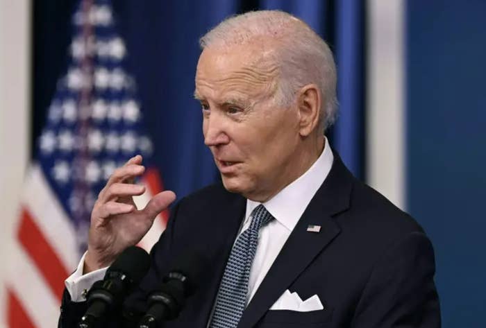 Biden in a suit standing in front of the american flag