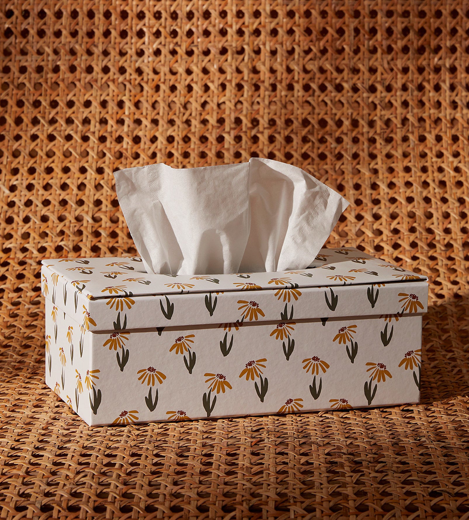 a floral tissue box holder on a rattan surface