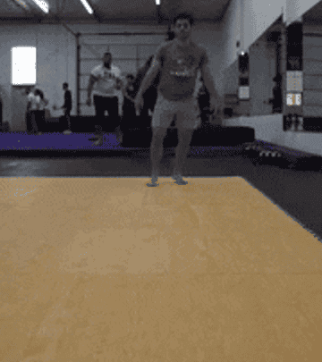 Dustin doing a rolling maneuver at his stunt gym then looking to the camera