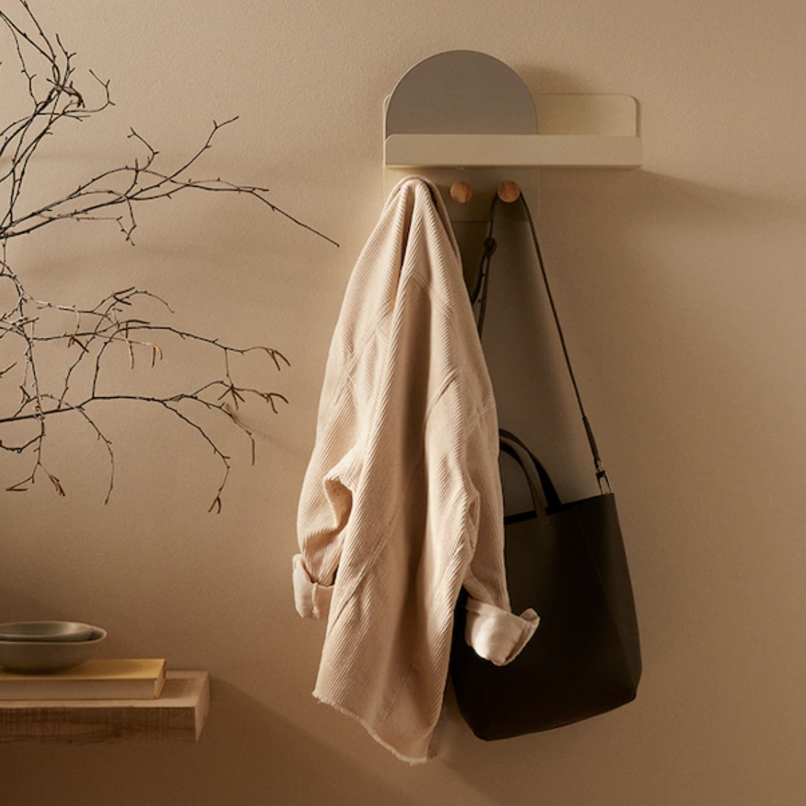 a stylish shelf with a jacket and a bag hanging off of it