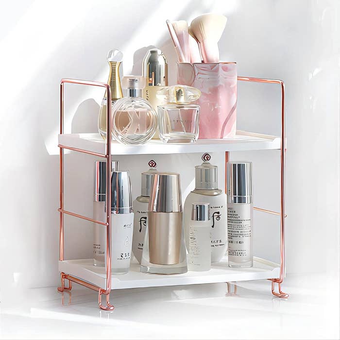 a rose gold shelf with skin care products on it