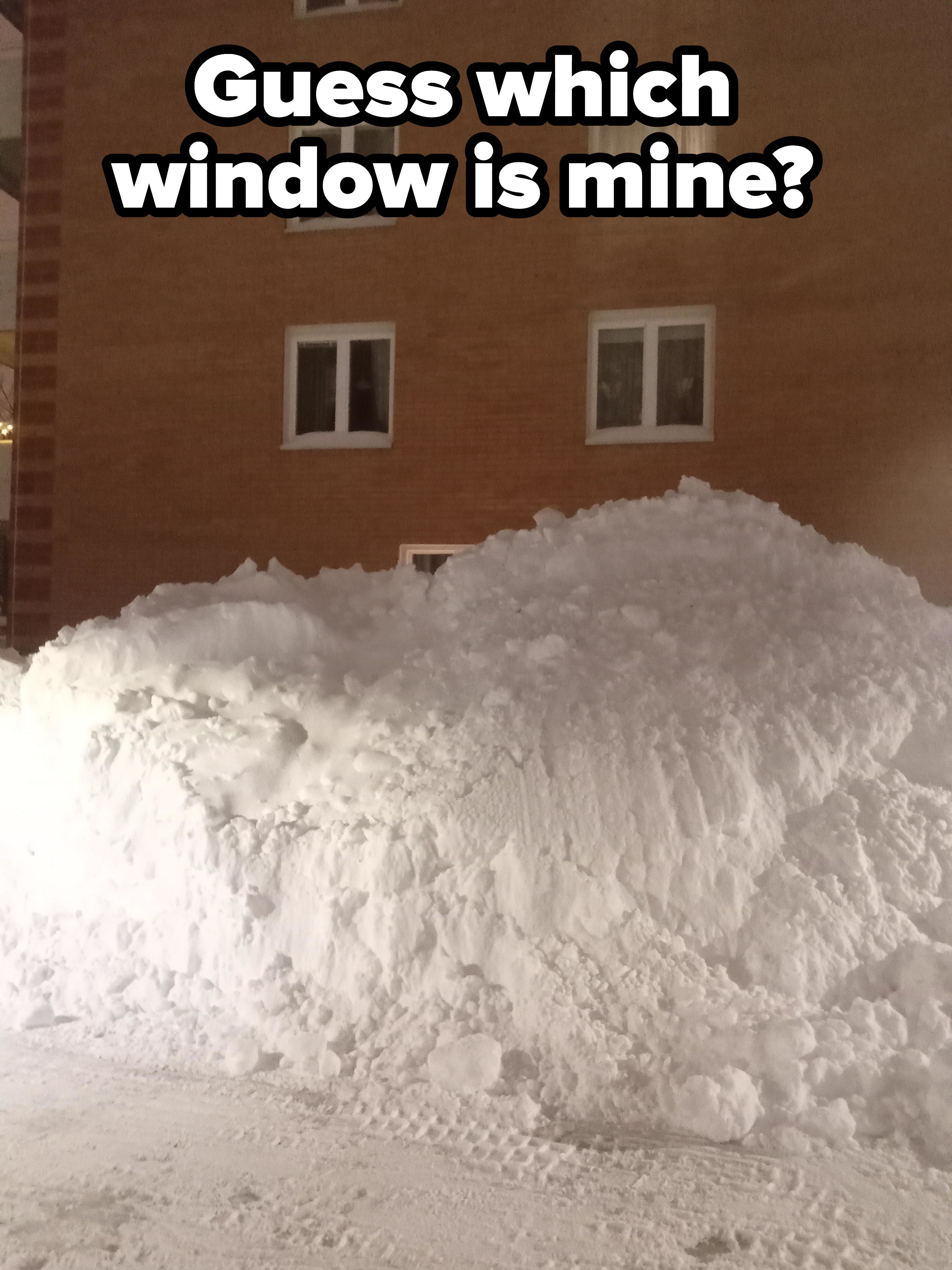 A mountain of snow covering the window of a building