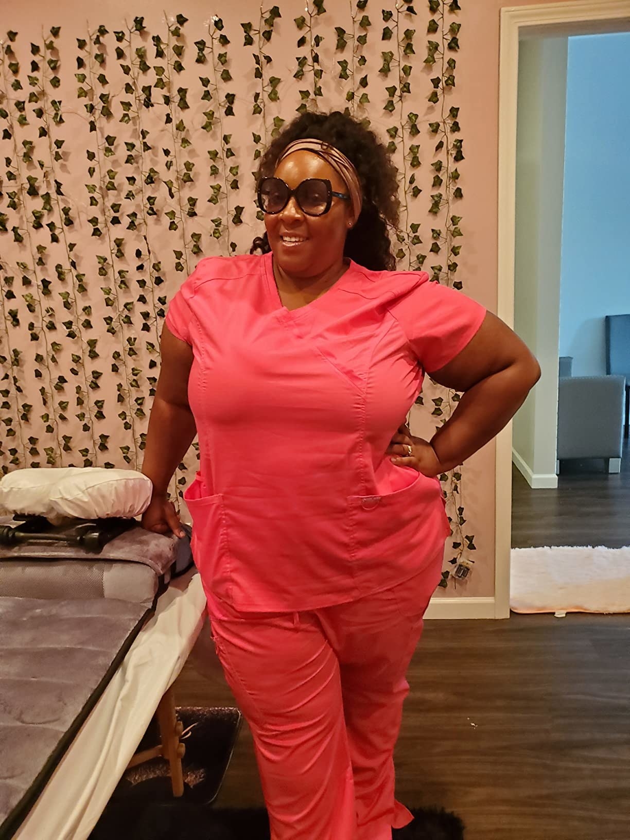 reviewer standing in pink scrub top with matching pants