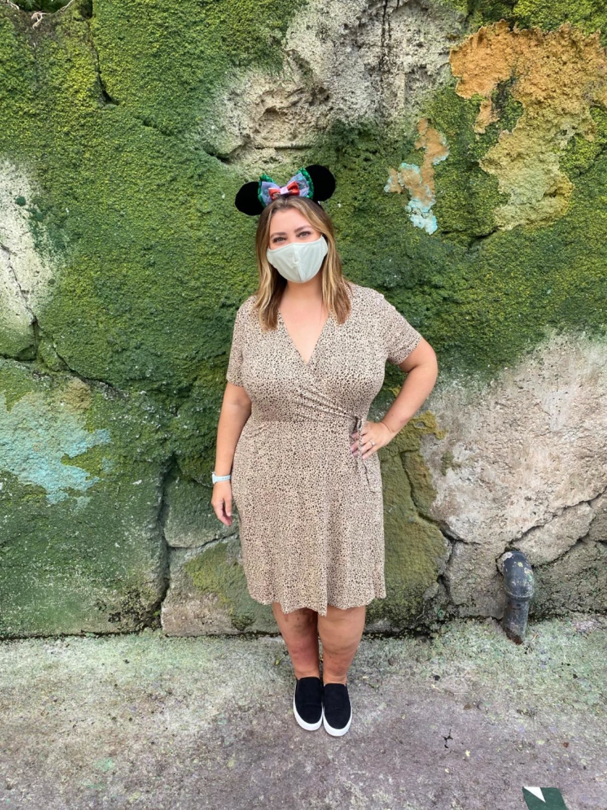 Reviewer standing outside on rocks in light printed dress with Minnie Mouse ears on