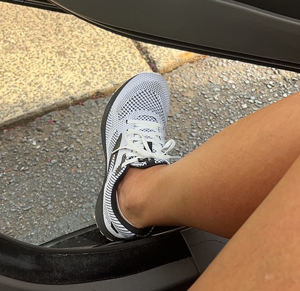 Reviewer stepping out of car in the white and black shoe