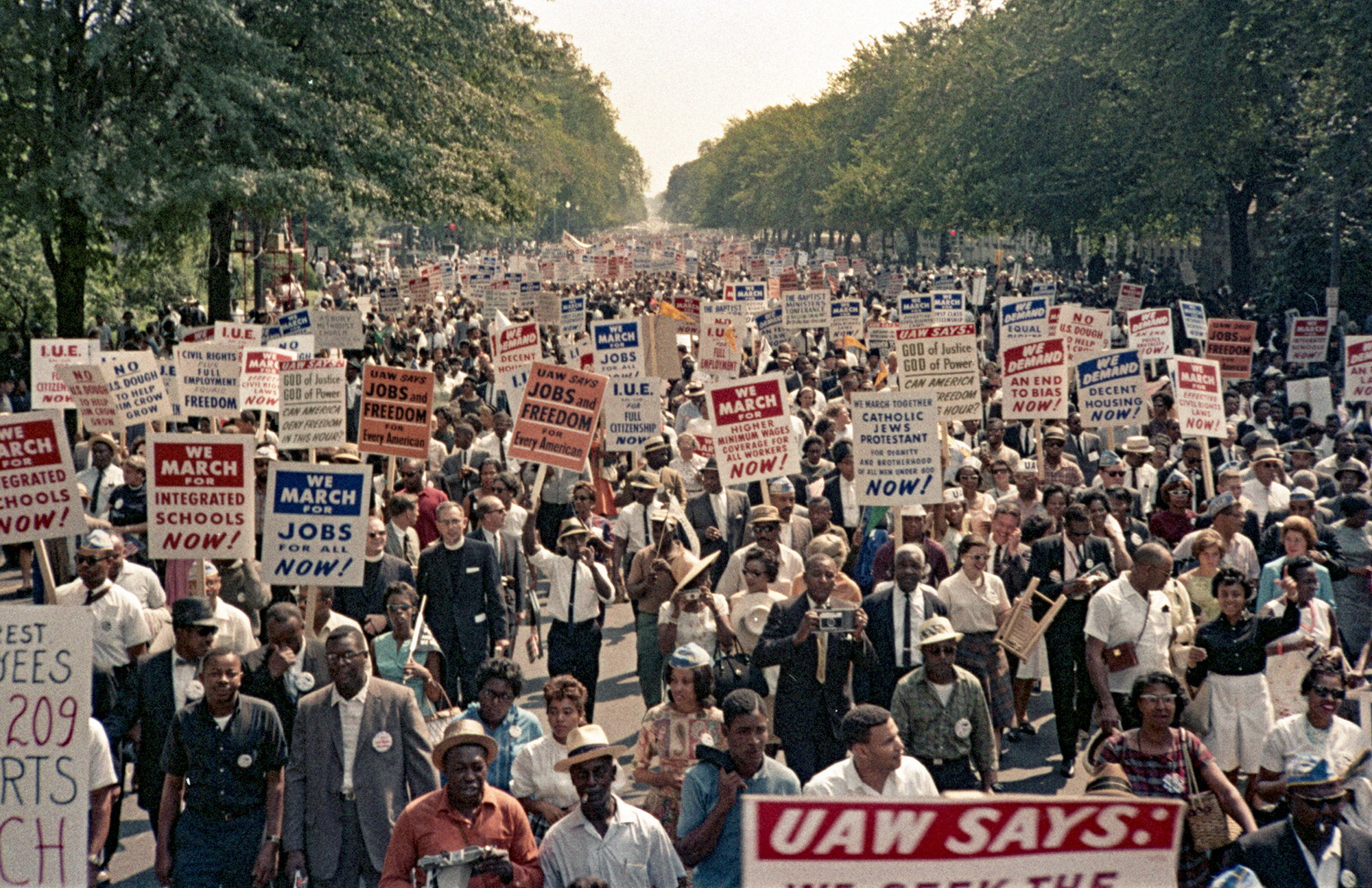 Attendees of the March on Washington walk with signs supporting equal rights.