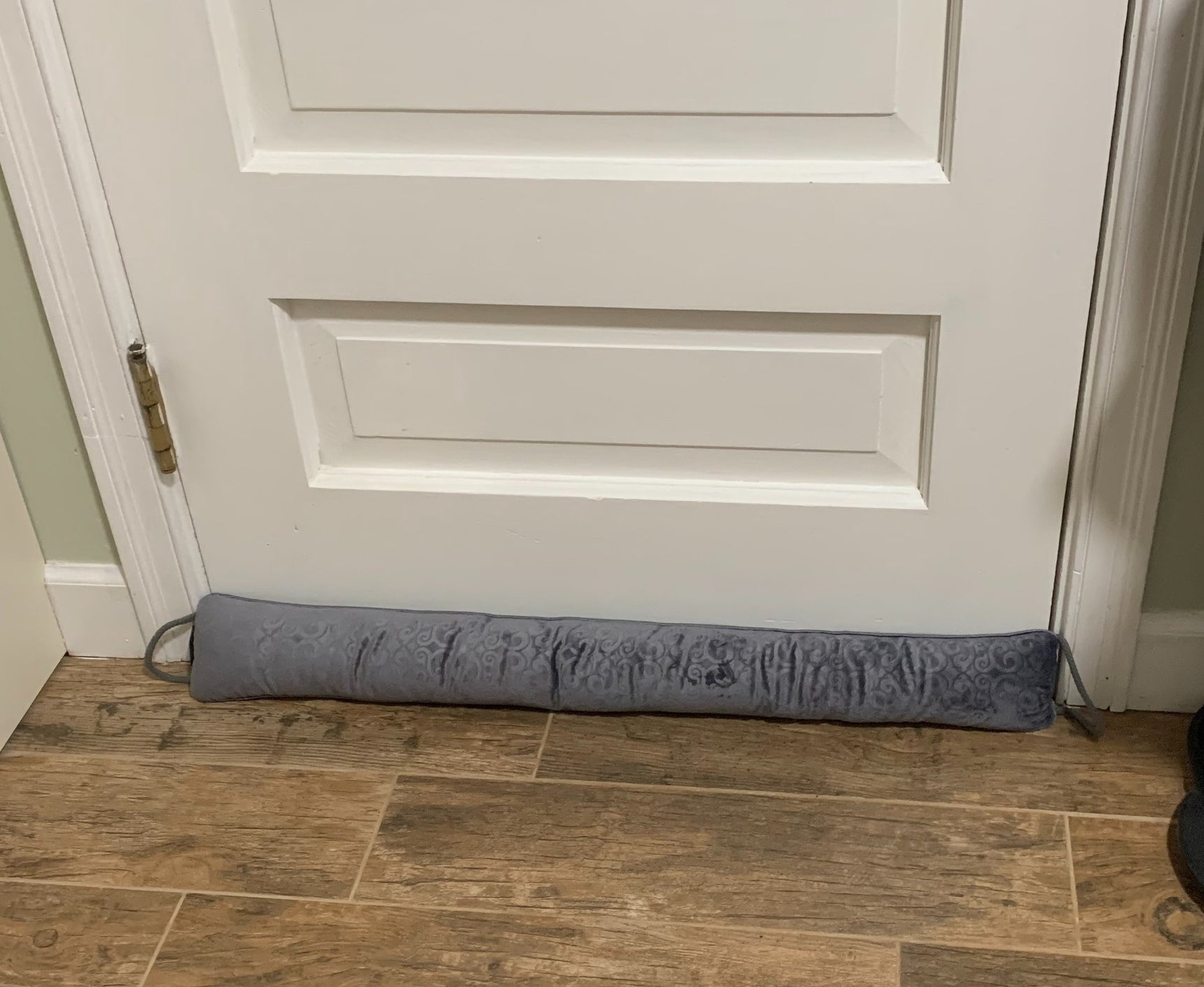 A reviewer picture of the gray door stopper against a white door