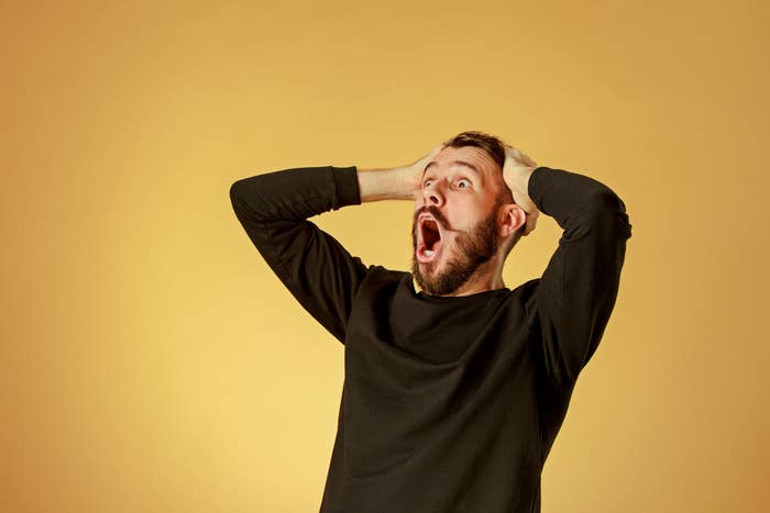 Man holding his head and looking stunned