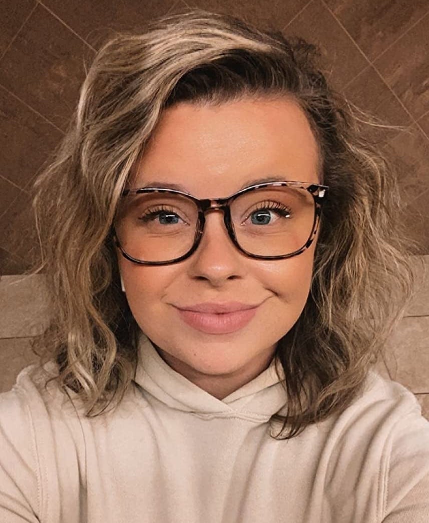 A reviewer wearing the blue-filtered glasses and smiling