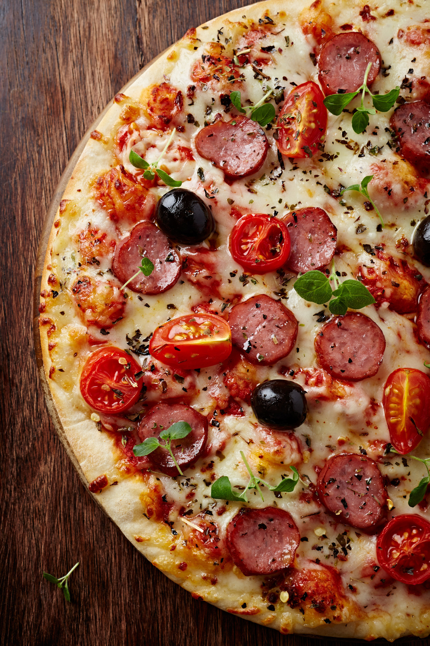 Pizza with pepperoni, cherry tomatoes and olives.
