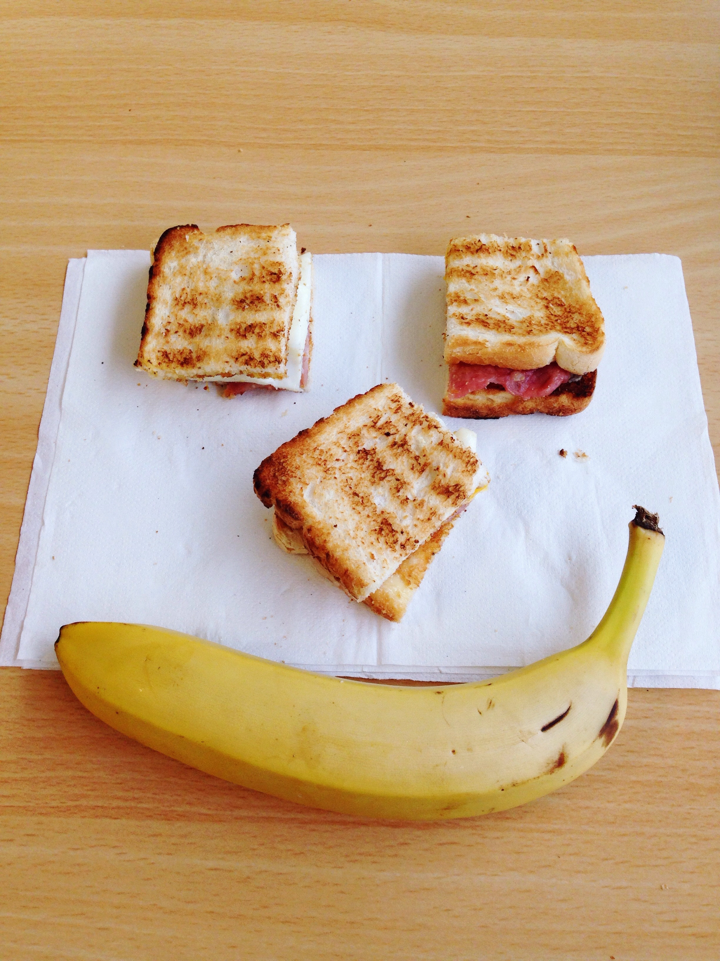 A cut toasted sandwich and a banana