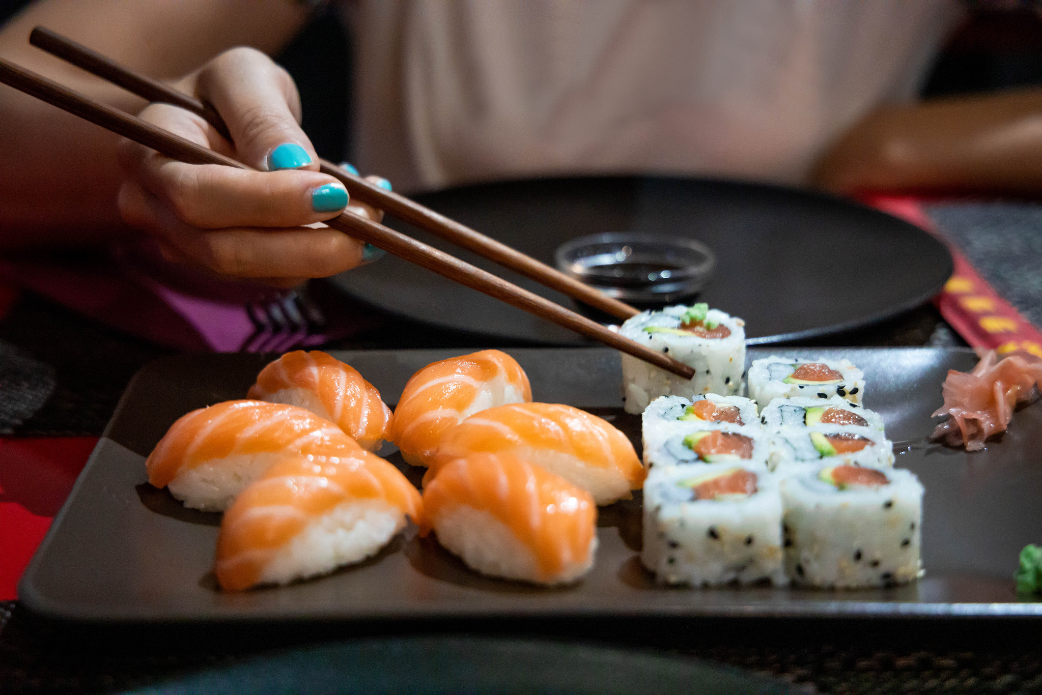 A person eating sushi with chopsticks