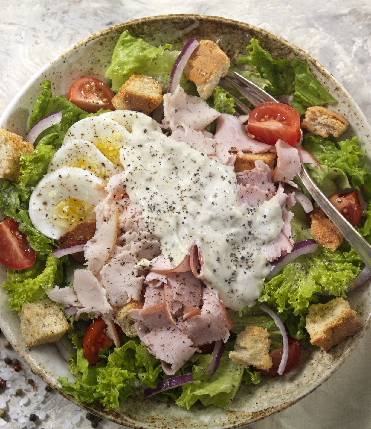 A chef&#x27;s salad coated with ranch dressing