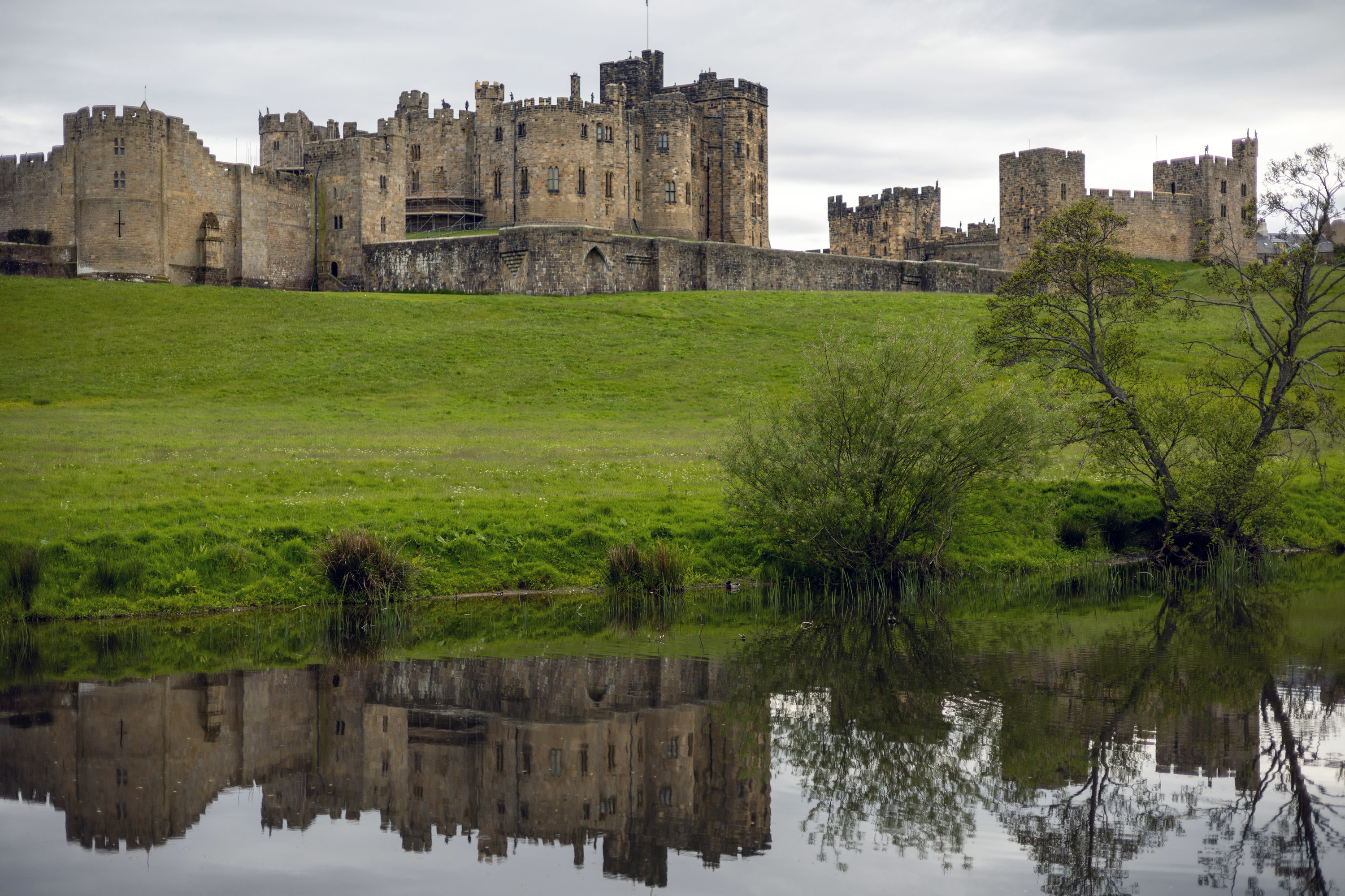 Scenic landscape of Alnwick Castle and the River Aln on overcast day, Northumberland, England, United Kingdom
