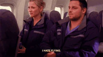 a woman says i hate flying whilst on a plane to a man sitting next to her
