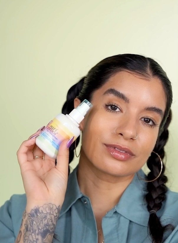 a person holding a bottle of the caliray setting spray to their face