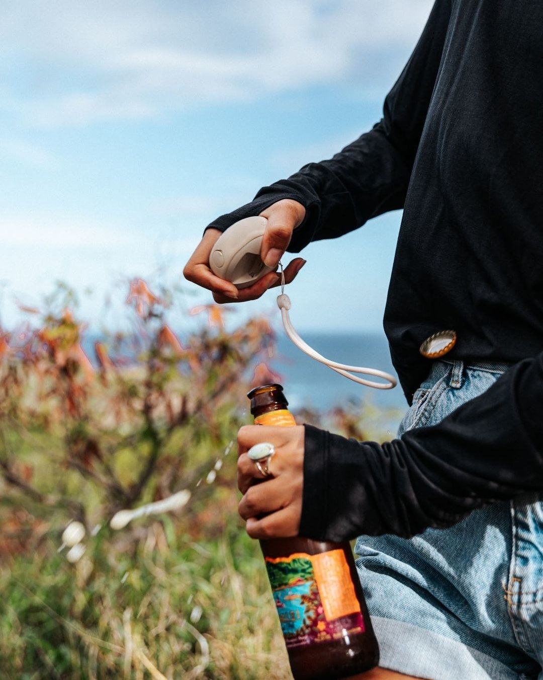a person using the speaker to crack open a glass bottle