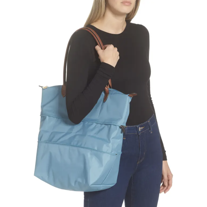 a person holding the unzipped le pliage tote