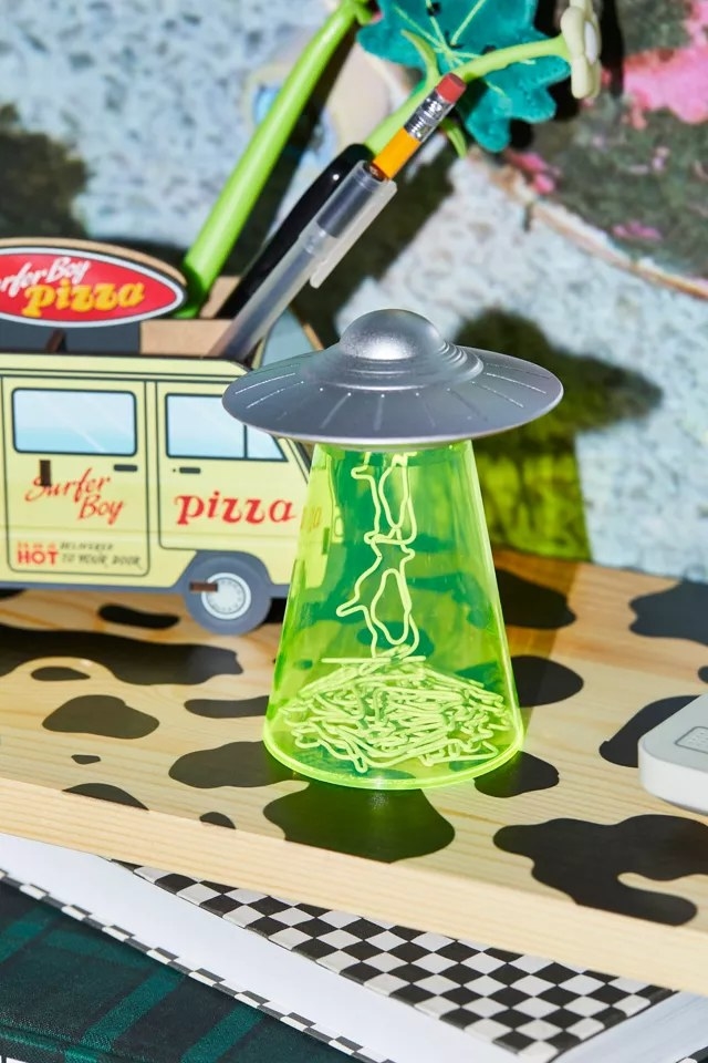 container that looks like ufo with green beam with cow paperclip stuff to top