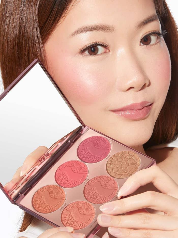 model holding blush and bronzer palette with six colors and a large mirror