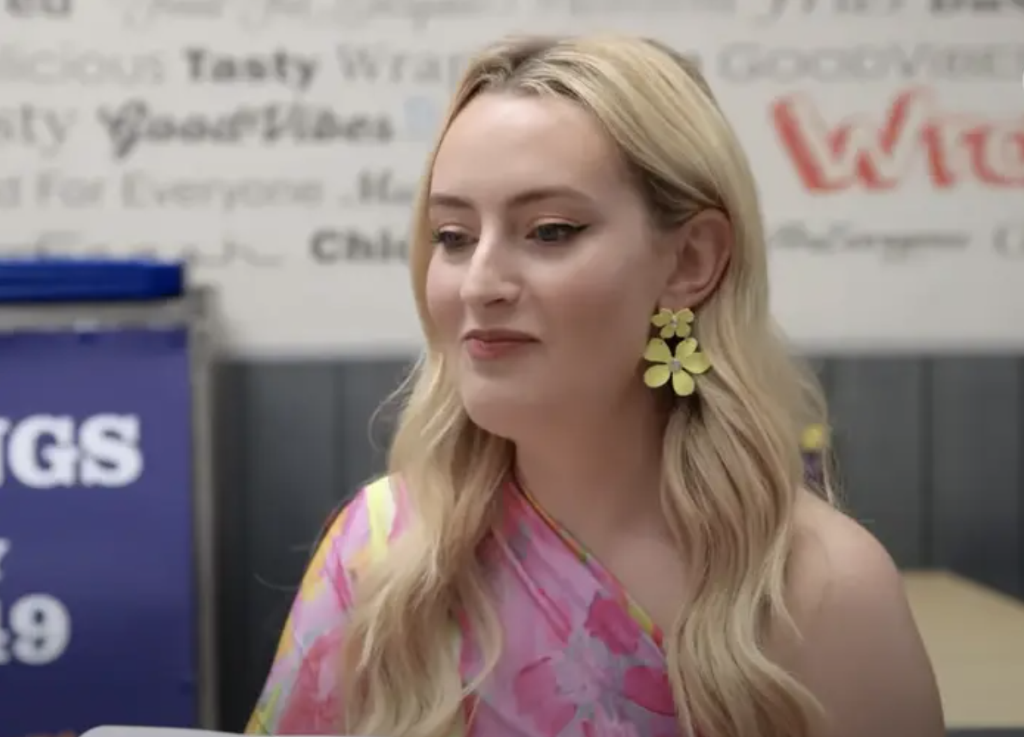 Amelia Dimoldenberg pursing her lips and wearing a pink one shoulder top.