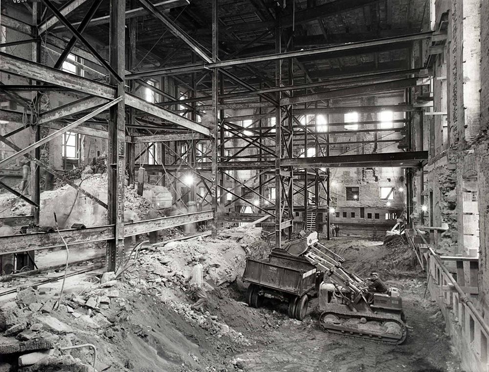 A construction/excavation area with mounds of dirt, a bulldozer, and scaffolding