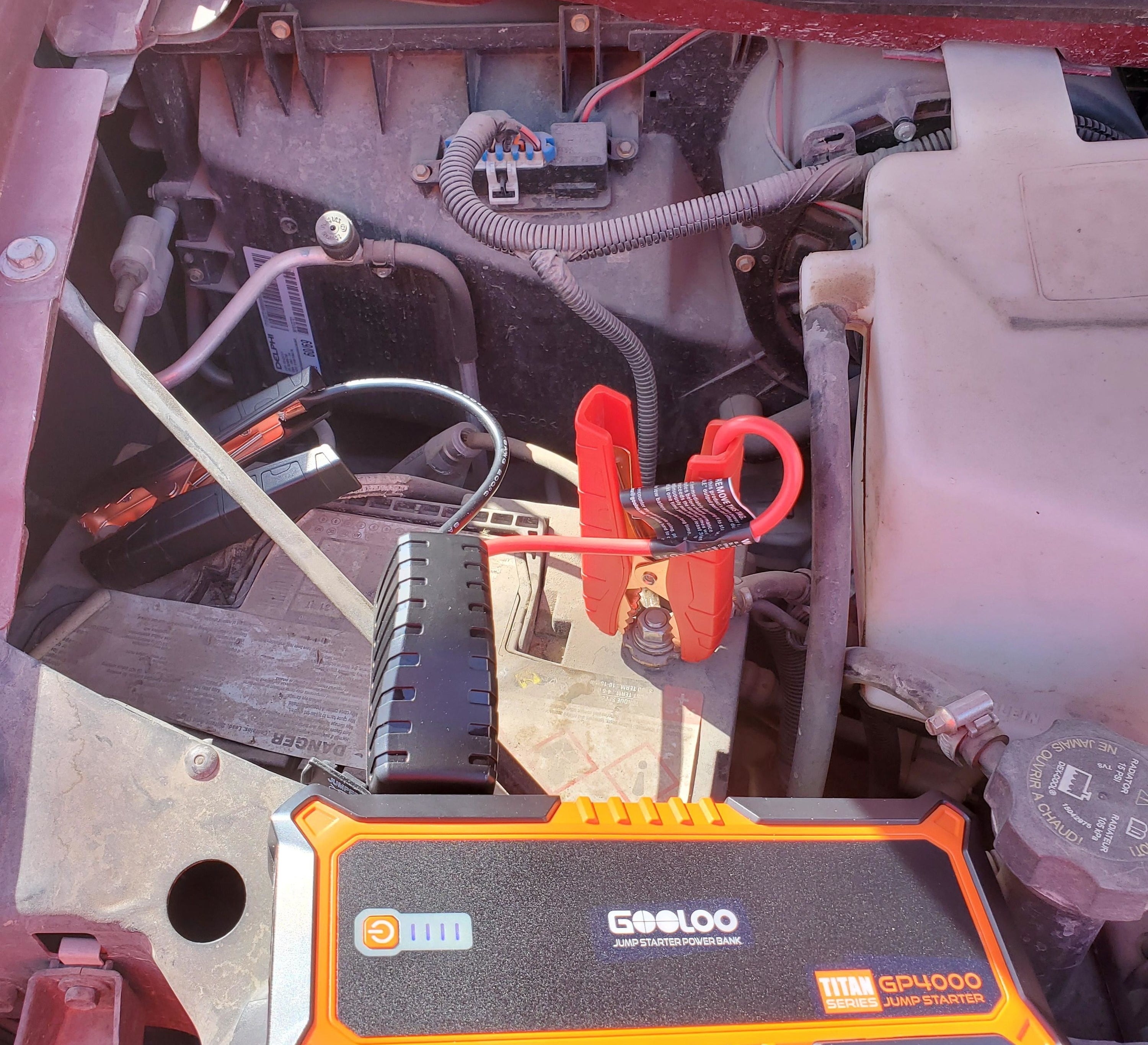 Reviewer using the orange jump booster pack on vehicle