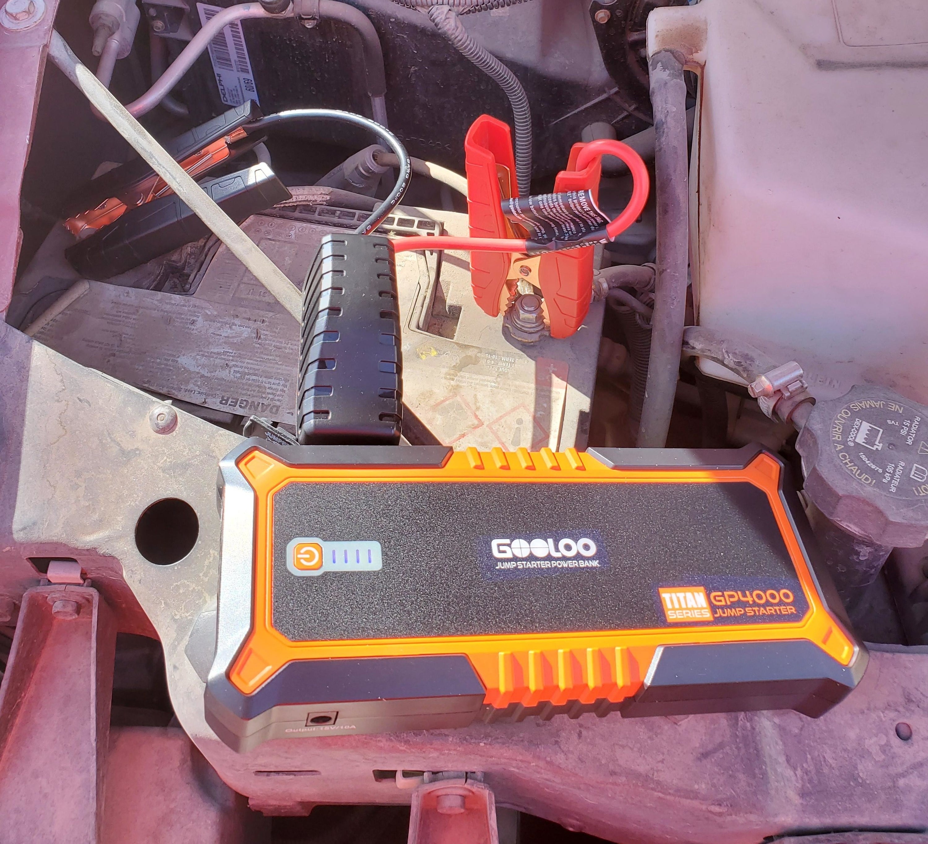 Reviewer using the orange jump booster pack on vehicle