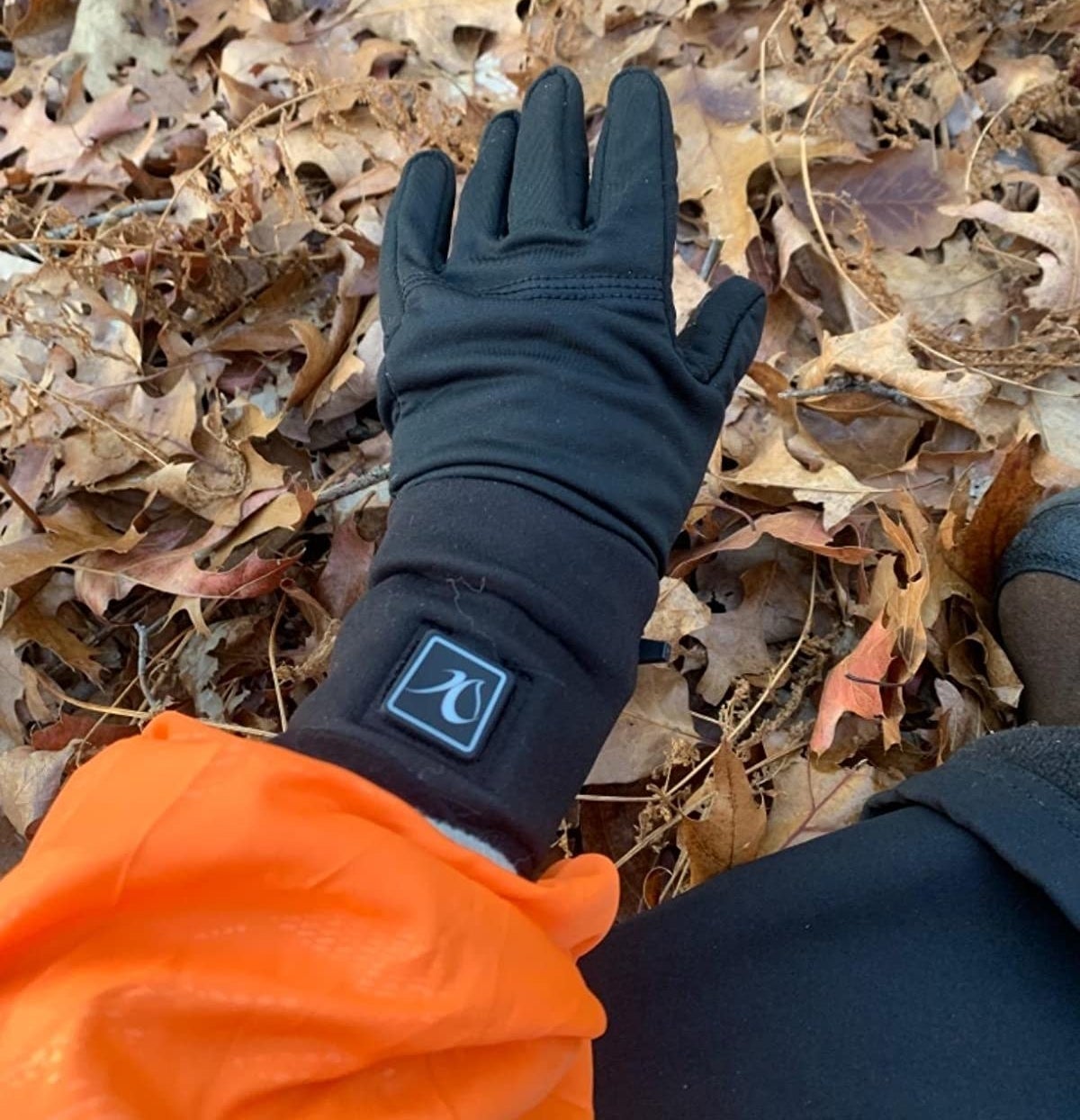 Reviewer wearing the glove outside in front of leaf pile