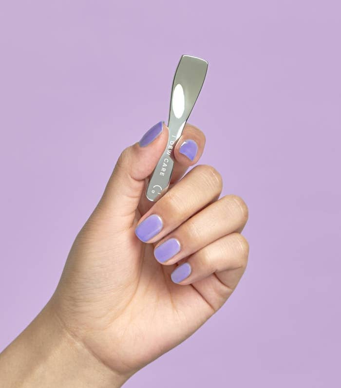 a person holding up the stainless steel beauty scoop