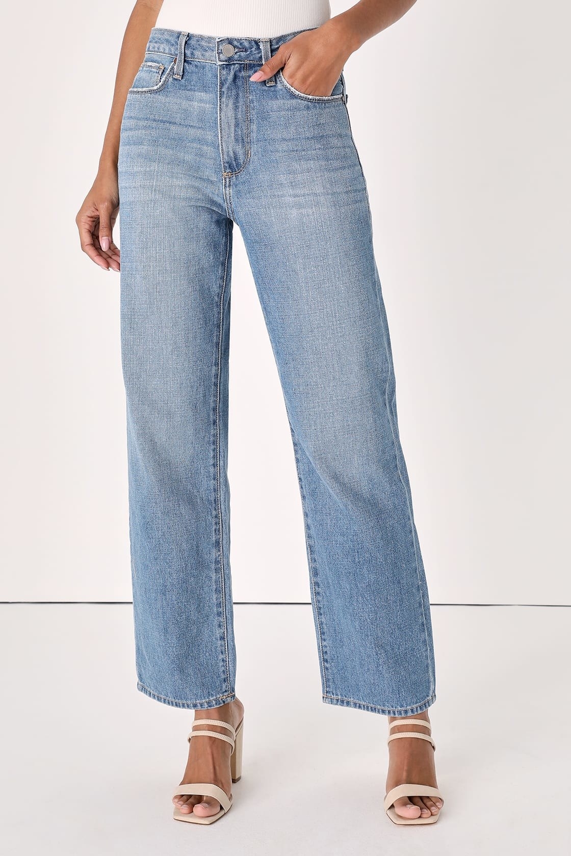 A model in a pair of wide-leg jeans with white shoes