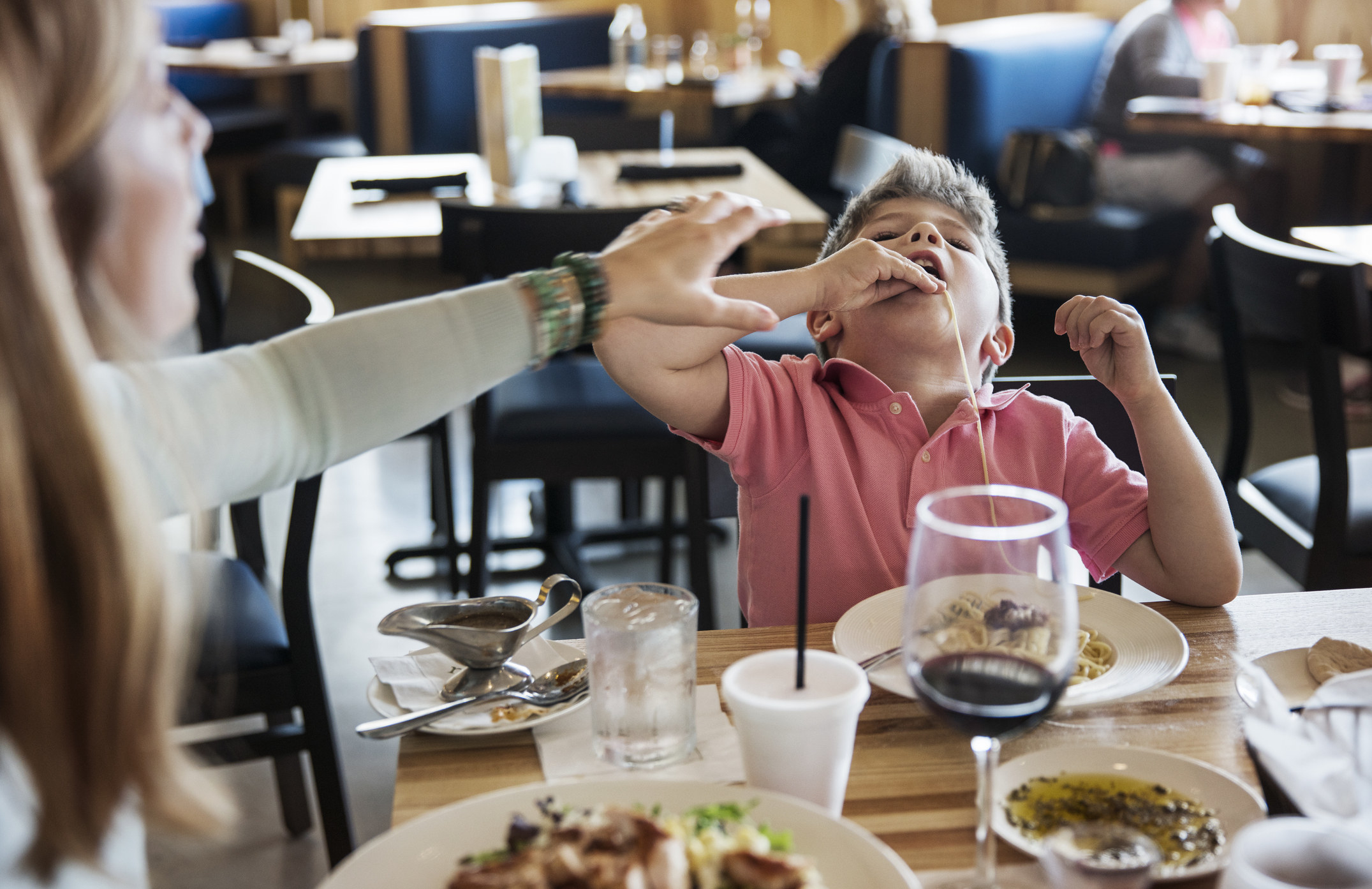 A little boy at a restaurant with his parents