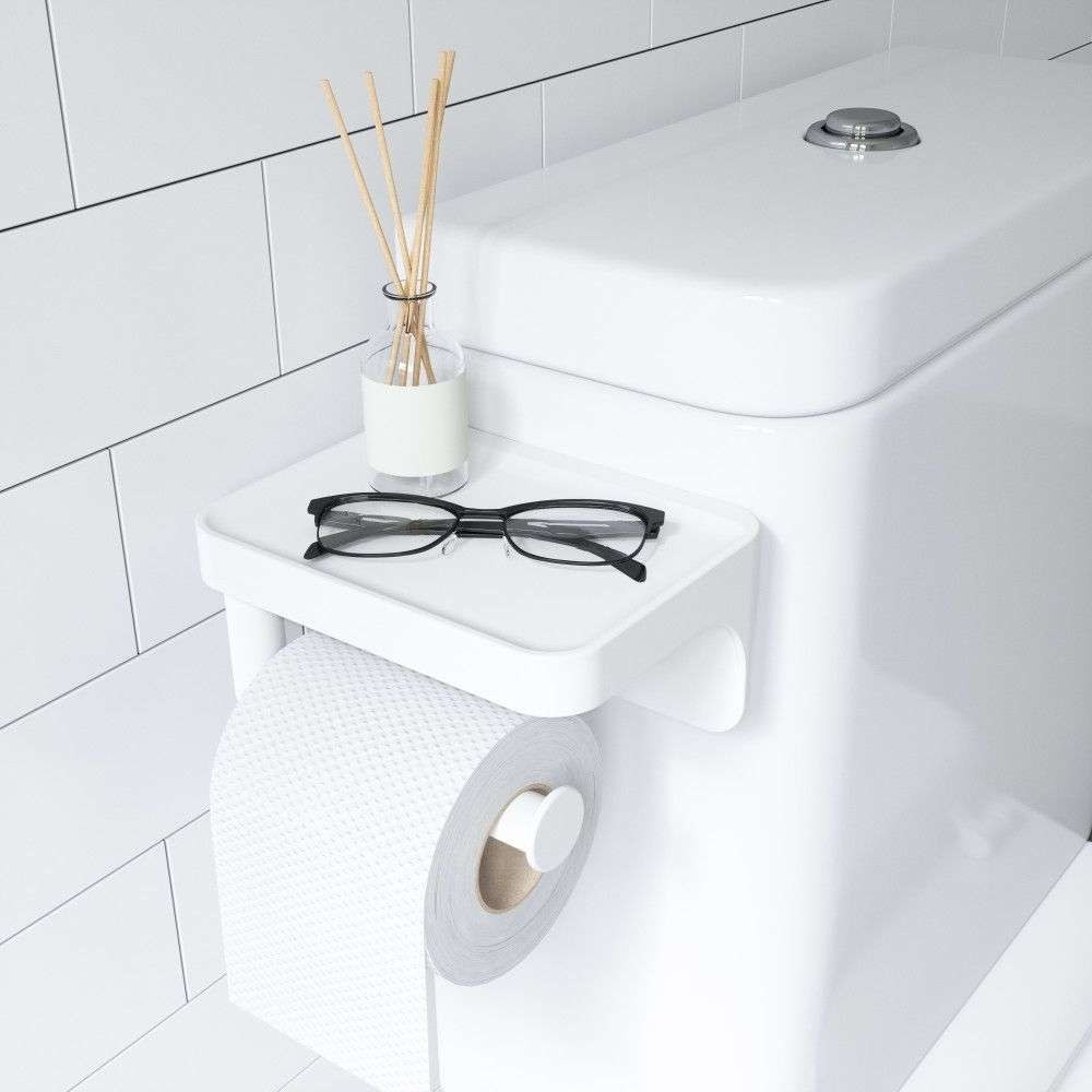 the toilet paper holder with glasses and diffuser rods on it