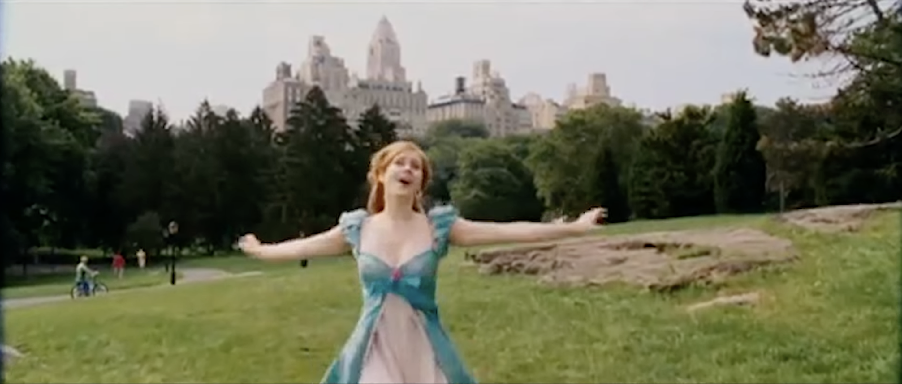 Giselle running through a park singing